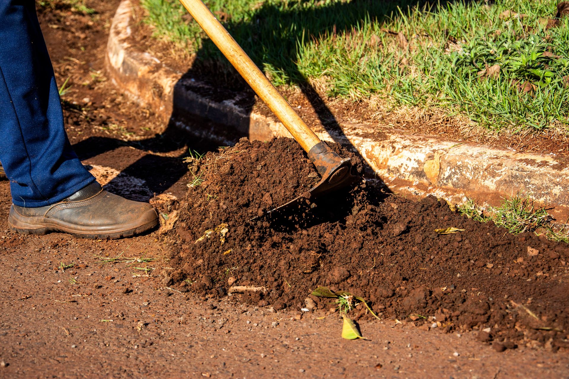 Close-up of gardener working soil using a hoe in Londrina, Brazil.